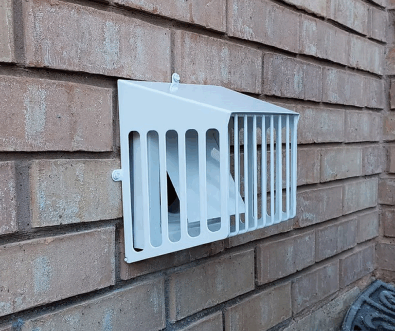 A technician is installing a bird guard on a dryer vent to prevent birds from entering and nesting in the ventilation system.